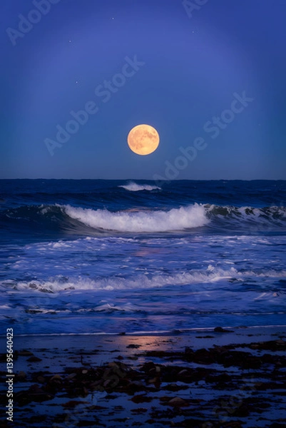 Fototapeta photo of the moon over the sea during a high tide with waves crashing against the shore. 