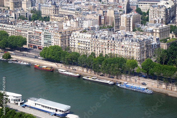 Fototapeta View of the Seine embankment and moored pleasure boats from the top of the Eiffel Tower on a bright sunny day.