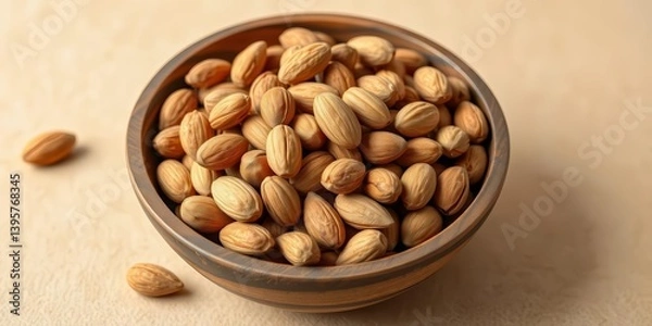 Obraz A rustic wooden bowl overflowing with shelled almonds sits on a beige backdrop, vegetarian, close up