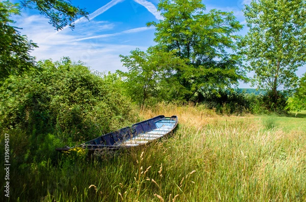 Fototapeta Una piccola barca di legno abbandonata in un prato nella campagna vicino al lago di Bolsena, nel Lazio