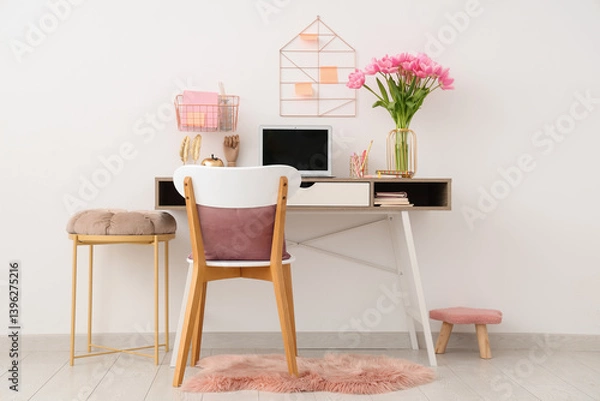 Fototapeta Interior of modern workplace with stools,  beautiful tulip flowers, laptop and stationery on table