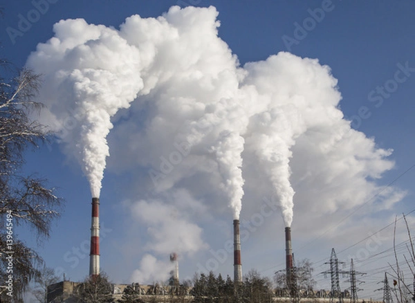 Fototapeta Smoking industrial chimneys. Combined heat and power. Air pollution clouds of smoke coming from the chimneys. Energy plant