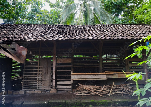 Fototapeta A rustic livestock shelter for cows or goats, surrounded by lush greenery and trees. a simple yet vital space for livestock care in the countryside