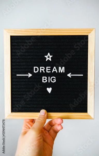 Obraz Hand holding a black felt board with wooden edges that has a big dream message in white letters