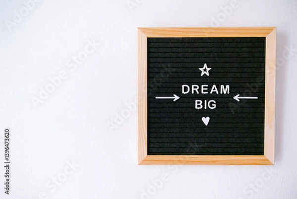 Obraz Black felt board with wooden edges and a message to dream big in white letters hanging on a white wall