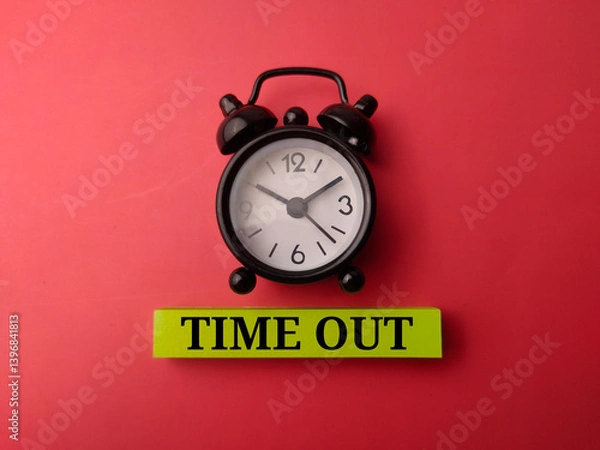 Fototapeta Alarm clock and sticky note with the word TIME OUT on a red background