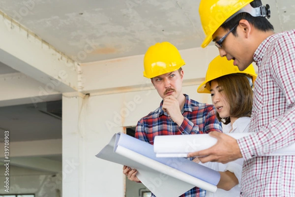 Fototapeta Engineer group and worker meeting, discussion with construction blueprint on site work