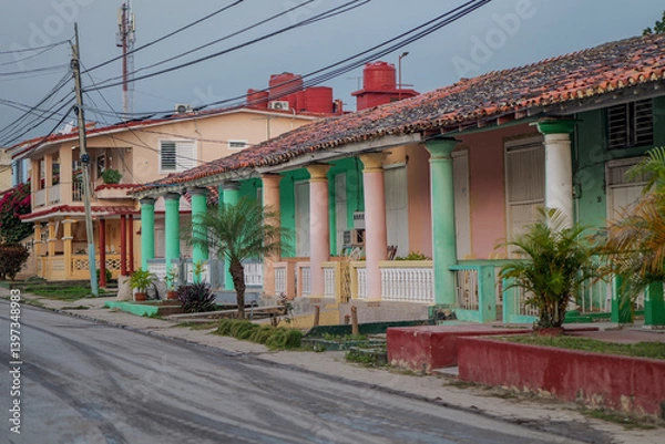 Obraz A row of charming, pastel-colored colonial houses in Viñales, Cuba, showcasing traditional architectural elements such as tiled roofs, wooden shutters, and classical columns. cuba