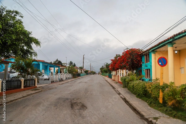 Obraz A row of charming, pastel-colored colonial houses in Viñales, Cuba, showcasing traditional architectural elements such as tiled roofs, wooden shutters, and classical columns. cuba