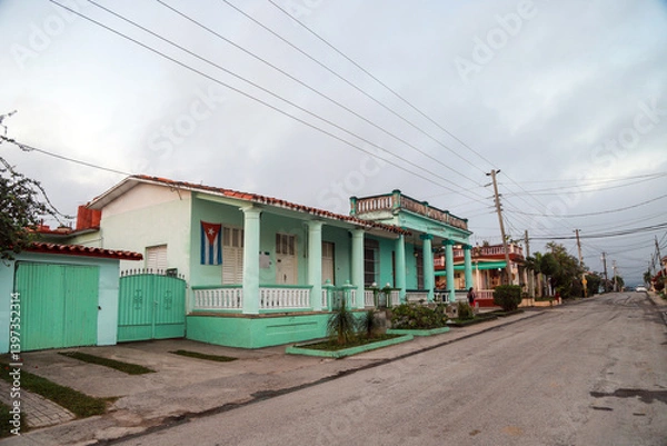 Obraz A row of charming, pastel-colored colonial houses in Viñales, Cuba, showcasing traditional architectural elements such as tiled roofs, wooden shutters, and classical columns. cuba