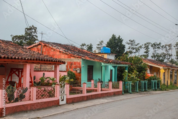 Obraz A row of charming, pastel-colored colonial houses in Viñales, Cuba, showcasing traditional architectural elements such as tiled roofs, wooden shutters, and classical columns. cuba