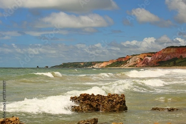 Obraz Green waters of a tropical beach in northeastern Brazil, with waves breaking water edge, sunny day, summer vacation at Tabatinga beach, Joao Pessoa.