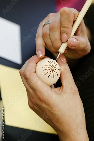 Obraz Woman hands painting Easter eggs with black bee wax, traditional Lithuanian method