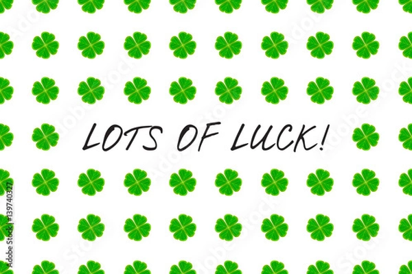 Fototapeta Saint Patrick's Day greeting card with green mosaic clover leaves and text on white background. Inscription - LOTS OF LUCK! vector illustration.