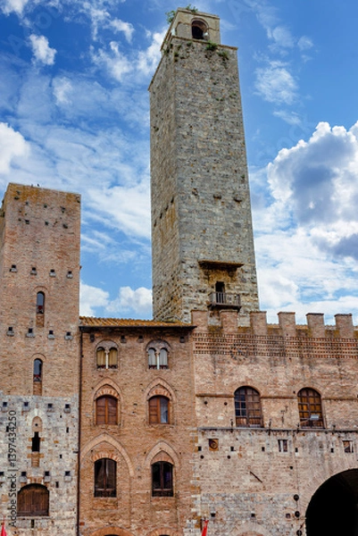 Obraz Torre Grossa rises majestically in the heart of San Gimignano, Italy, surrounded by historic buildings and a stunning blue sky, showcasing the region's architectural heritage.