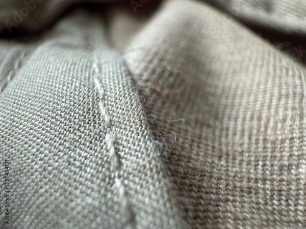 Fototapeta Close up of fabric texture highlighting stitching and fibers in neutral tones demonstrating detailed craftsmanship