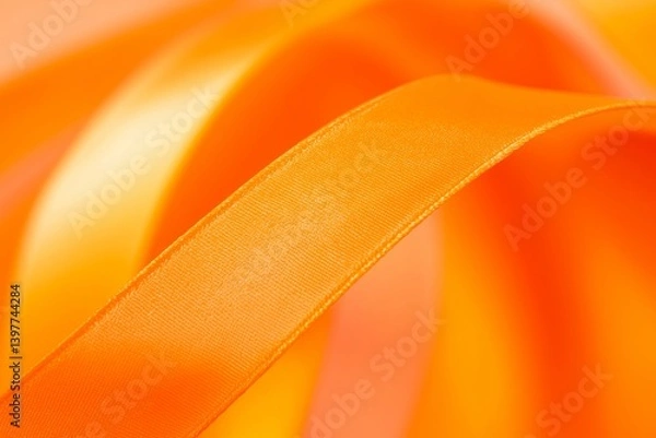 Fototapeta A close-up of an orange ribbon twisting and turning, representing creativity and playful elegance.