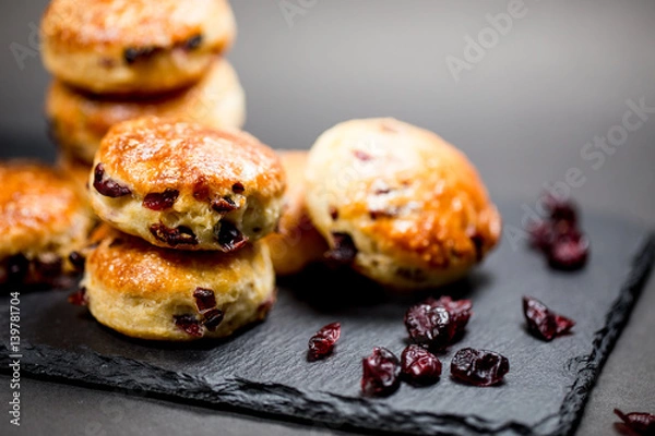 Obraz Traditional delicious British pastry and desert - scones with dry cranberry in black background.Home baking.