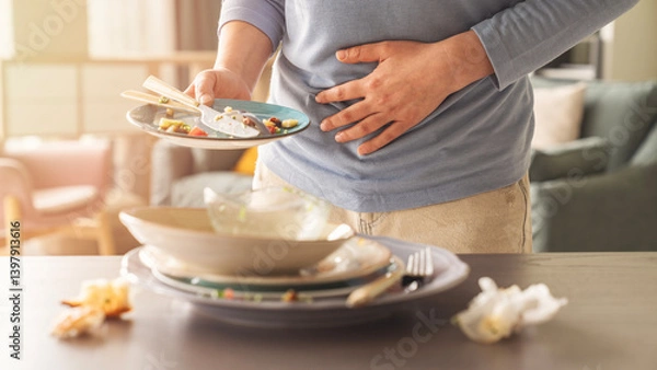 Obraz Woman with bloating and stomach ache from overeating