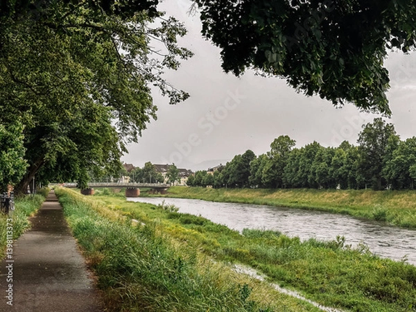 Fototapeta Bridge spans a river, with a path running alongside it