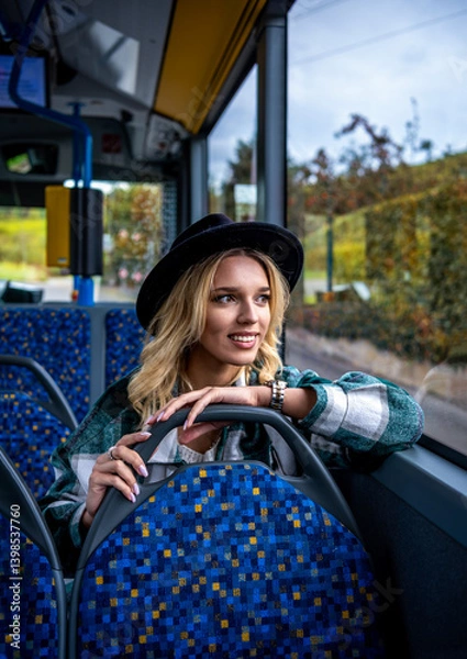 Fototapeta Smiling woman traveling by bus on an autumn day in Stuttgart, Germany
