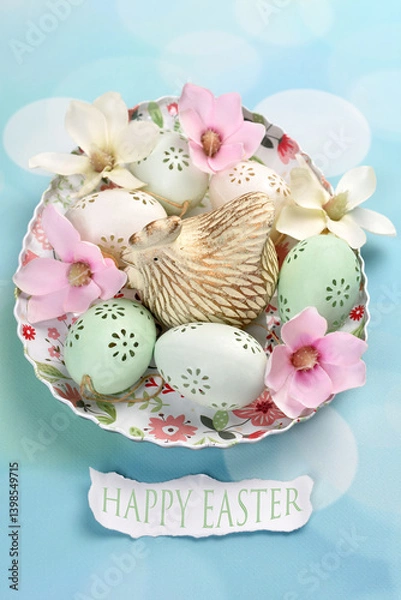 Obraz Easter card with egg shaped plate filled with hen figurine, eggs and magnolia blossoms