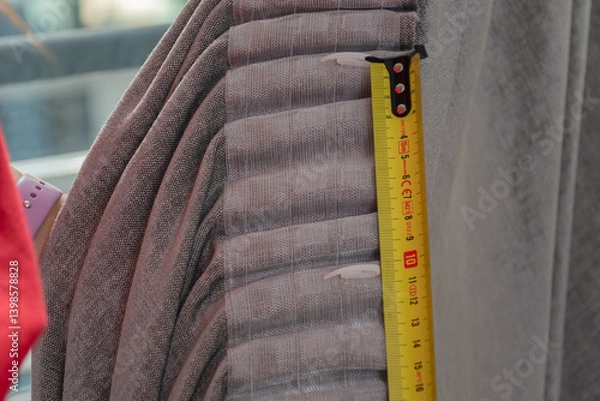 Fototapeta Construction roulette is applied to anger at the folds of the curtains. Curtain with hooks close-up
