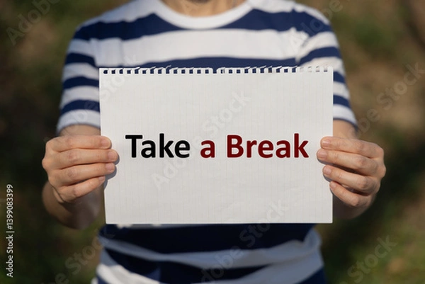 Fototapeta Take a break text on notebook paper holding by a woman