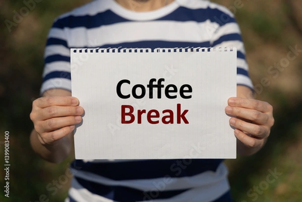 Fototapeta Coffee break text on notebook paper holding by a woman