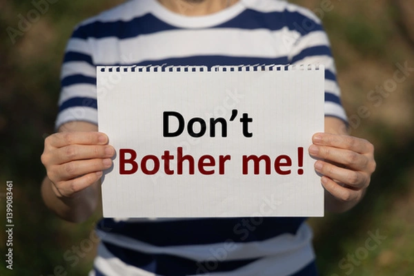 Fototapeta Don't bother me text on notebook paper holding by a woman