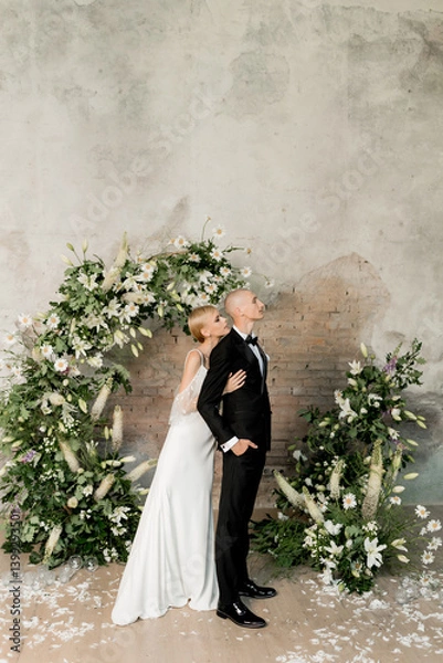 Fototapeta Young beautiful happy couple hugging and smiling near the arch