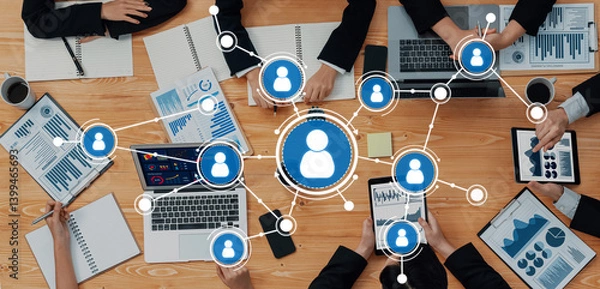 Fototapeta A dynamic business meeting scene showcasing technology and networking elements, where diverse professionals collaborate over laptops and presentations, enhancing productivity. Amity