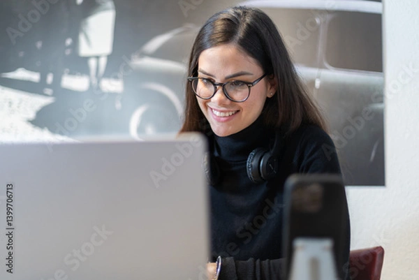 Fototapeta Happy woman smiling while working on her laptop from home.