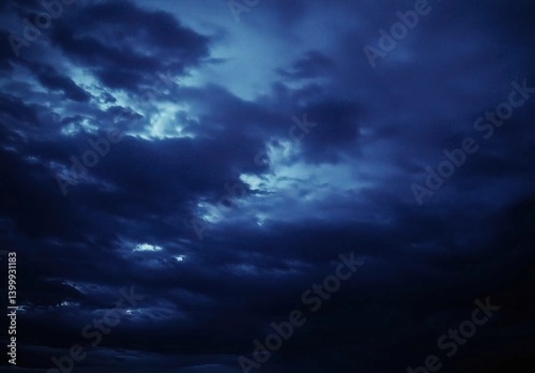 Fototapeta Dark Blue Clouds Rolling Across the Sky with Mysterious Light Peering Through