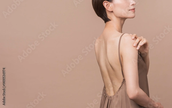 Fototapeta 美しいアジア人女性のビューティーイメージ。彼女は背中が見えるドレスを着ている。