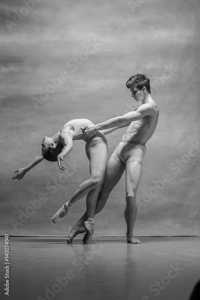 Fototapeta Couple of ballet dancers posing over gray background