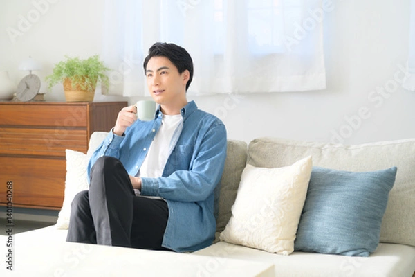 Fototapeta ソファでくつろぐ日本人男性
