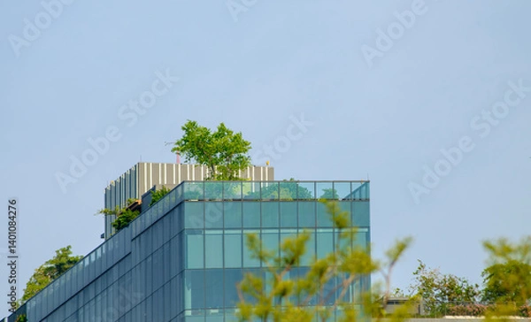 Fototapeta Modern building rooftop garden with trees and blue sky
