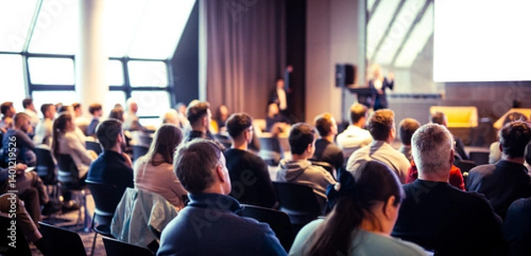 Fototapeta Speaker giving a talk in conference hall at business event. Rear view of unrecognizable people in audience at the conference hall. Business and entrepreneurship concept