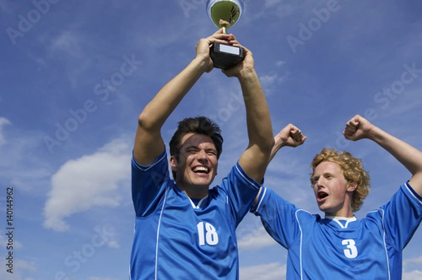 Obraz Cheering kickers holding a cup