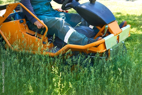 Obraz Summer care.Professional grass cutting on lawns with a lawn mower tractor
