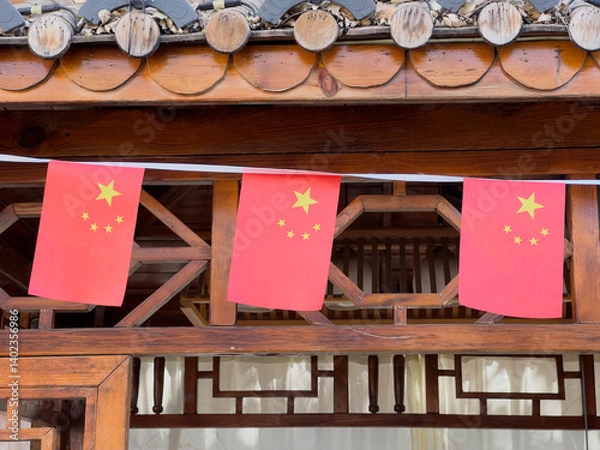 Obraz Chinese flags hanging on a traditional wooden building.