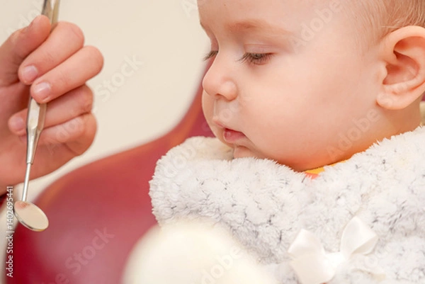 Fototapeta Child experiences dental checkup with dentist using tools in clinic environment on a bright day