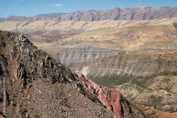 Fototapeta Dry mountainous terrain near Maragua, Bolivia, showing exposed stratified rock layers, red ridges, eroded slopes, and folded sediment formations typical of Andean geology.