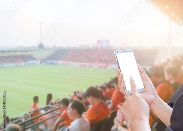 Obraz Kobieta ręce za pomocą telefonu komórkowego na stadion piłkarski
