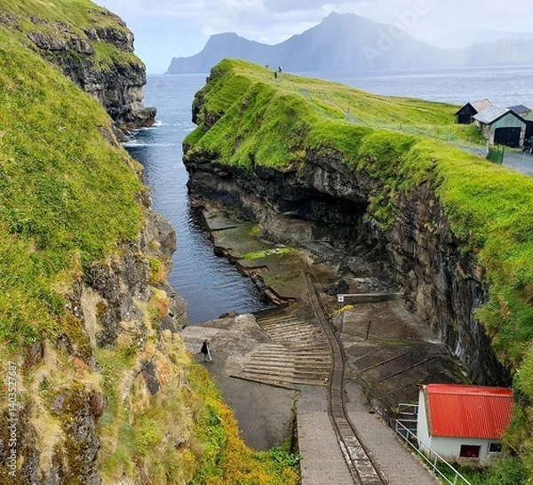 Obraz The Gjogv village on the Faroe Islands, named after a 200-metre (650 ft) long sea-filled gorge that runs to the sea from the village.