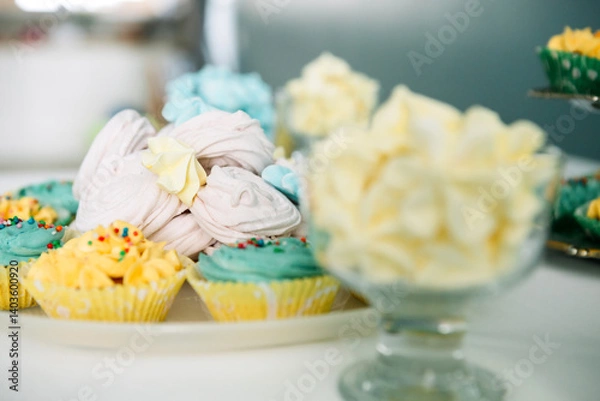 Fototapeta Festive bright cupcakes and cakes on the table, Side view.