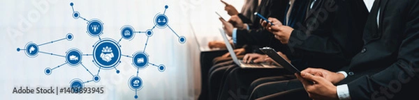 Fototapeta Business professionals interact with digital devices in a modern corporate space, illustrating the importance of technology and networking in the contemporary workplace. Amity