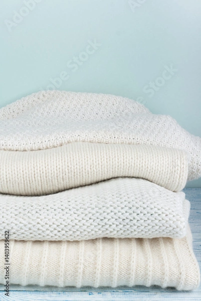 Obraz Knitted wool sweaters. Pile of winter clothes on green wooden background, , knitwear, space for text.