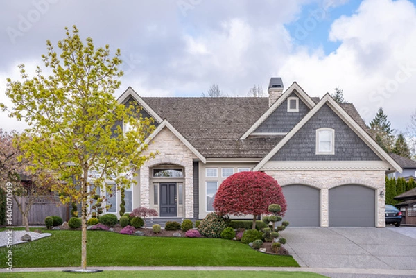 Fototapeta Two story stucco luxury house with nice spring blossom landscape in Vancouver, Canada, North America. Day time on April 2025.